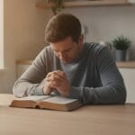 Open Bible with hands folded in prayer, offering reassurance to those struggling with sin and doubt